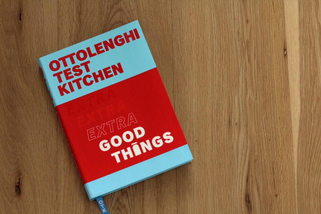 Front cover of a cookbook, with thick bands of red and blue and the text 'Ottolenghi Test Kitchen: Extra Good Things'.